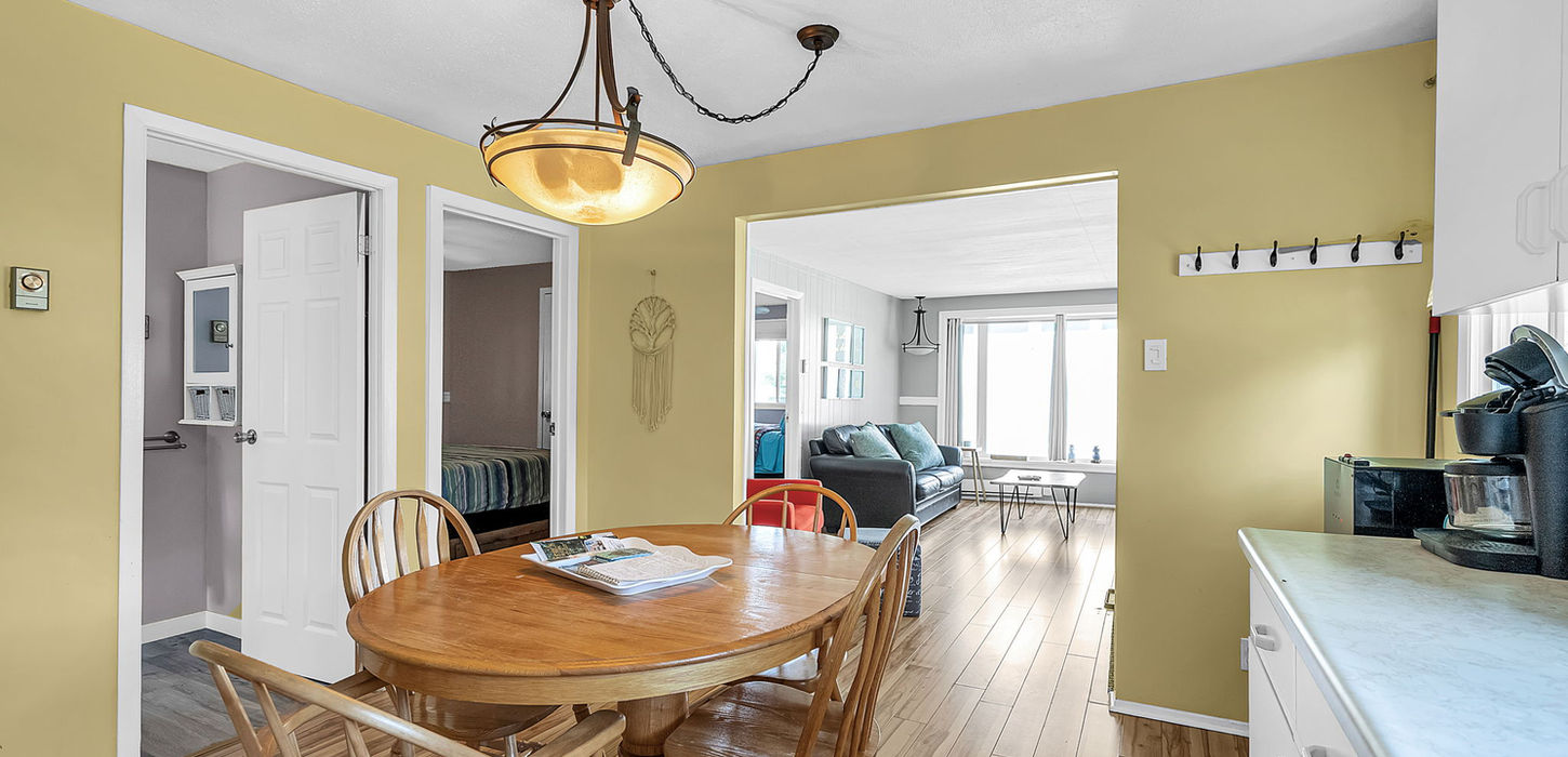 Kitchen table and chairs with the living room in the background in Cottage 2: The Sweet Retreat.