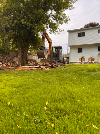 Lawn with backhoe removing loose debris