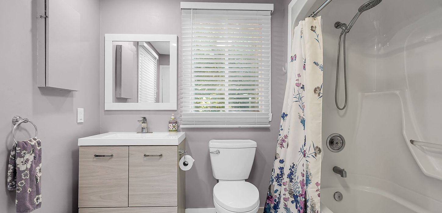 Bathroom with vanity, toilet and shower in Cottage 3: The Creekside Cabin.