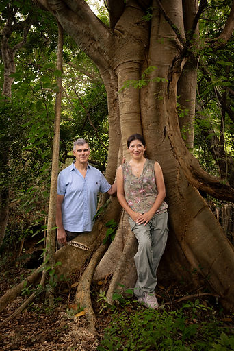 Paul & Sophia posing near a large tree in a forest setting.