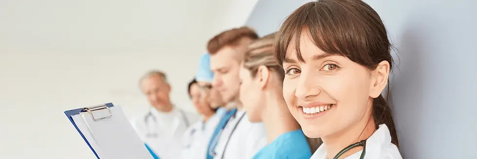 A smiling female doctor stands in the foreground, while a group of medical professionals, both male and female, review documents in the background.