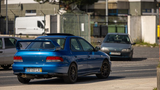 Famílias e entusiastas reunidos junto a automóveis clássicos no parque, celebrando o Dia da Mulher em ambiente festivo