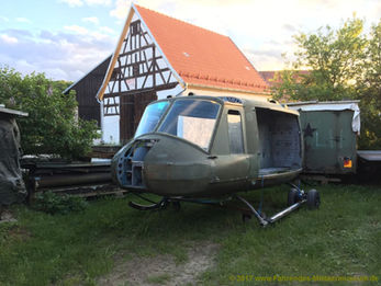 Bell-UH-1 vor einem Haus