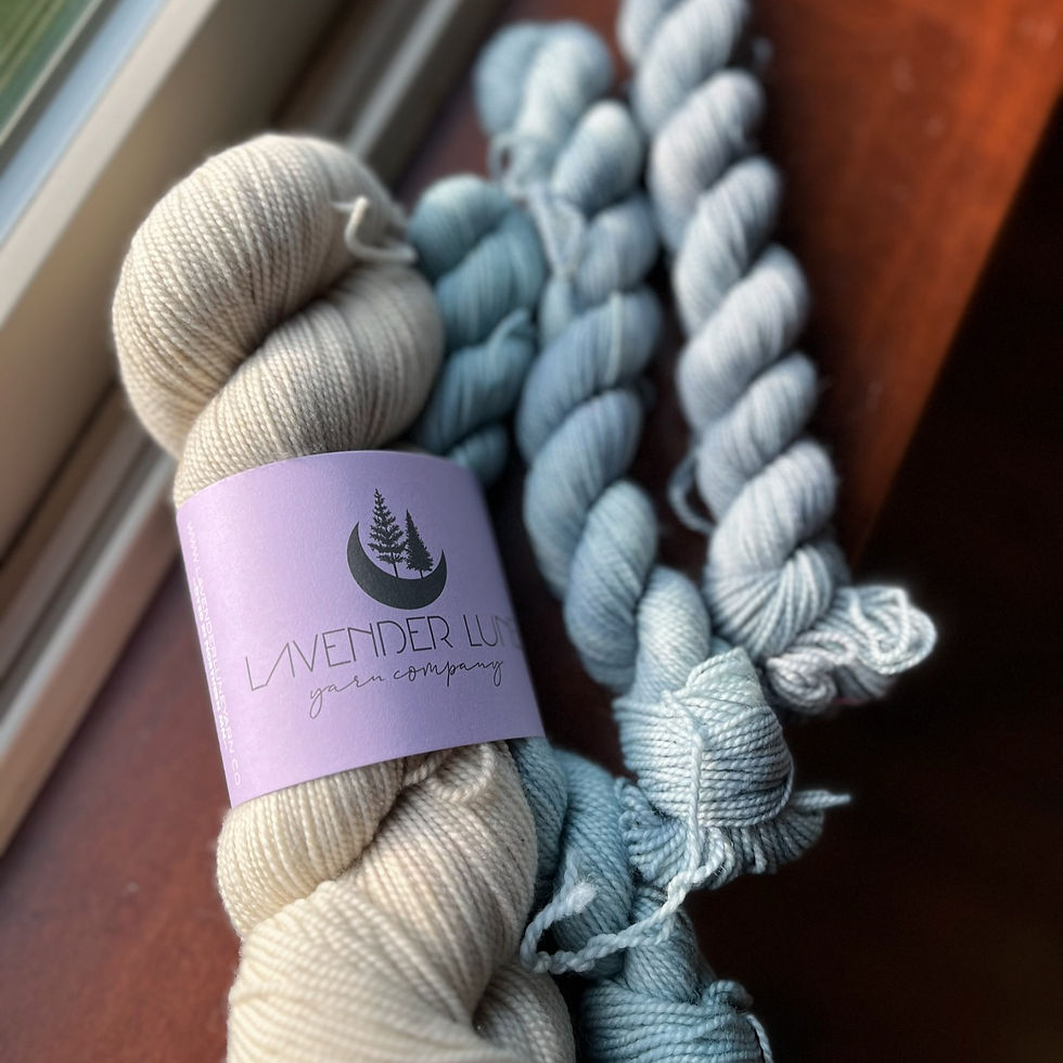 a full skein of cream yarn and three mini skeins of light blue yarn ready and waiting to be knit up into an amazing design for the up