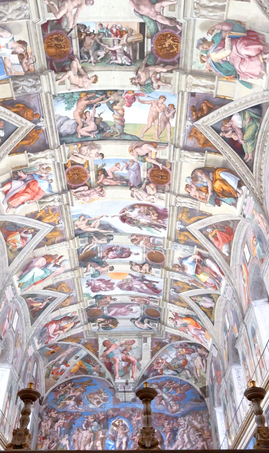 Intricate frescoes on a chapel ceiling depict biblical scenes with vibrant colors and dynamic figures, creating a dramatic, spiritual atmosphere.