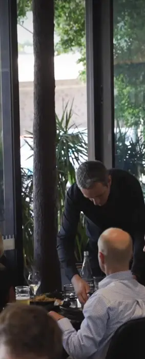 Server presenting dishes to guests at DUCKFAT restaurant in Brisbane