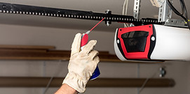 Technician performing service and tune up on a garage door in Placitas, NM