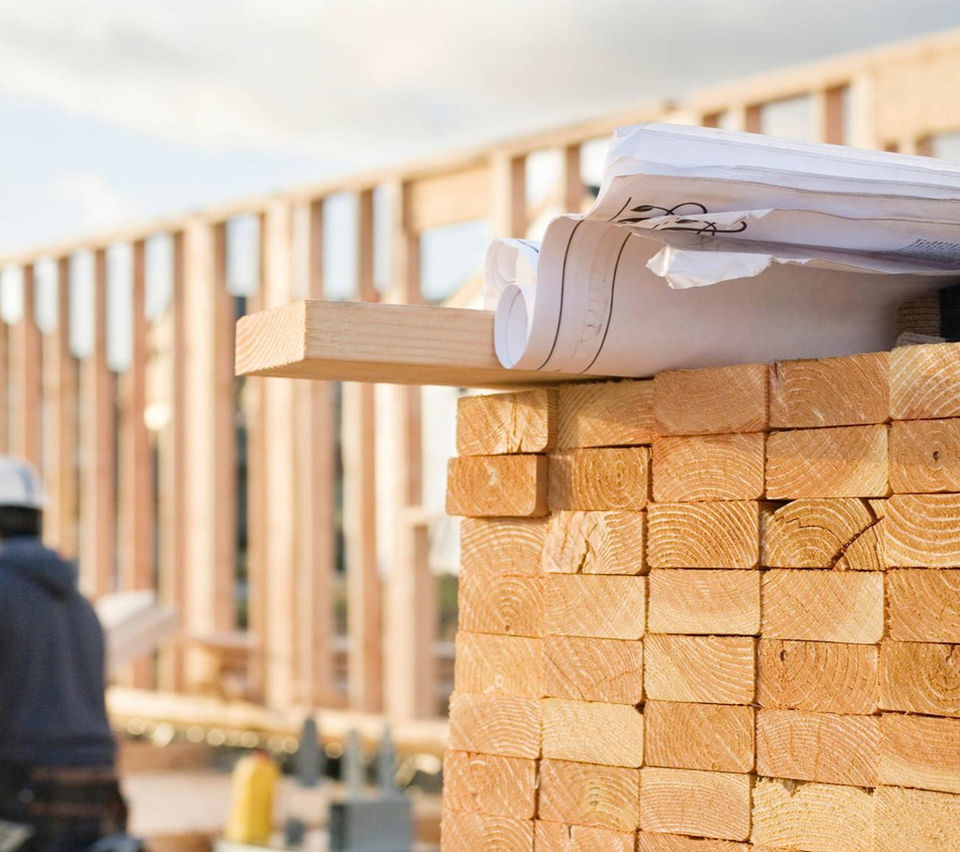A construction worker engaged in various activities at a bustling building site, ensuring precise quantity and material takeoffs.