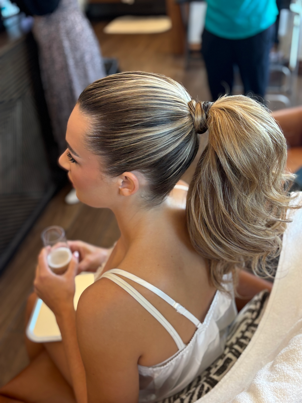 A high angle of our bride wearing a high, full glam ponytail