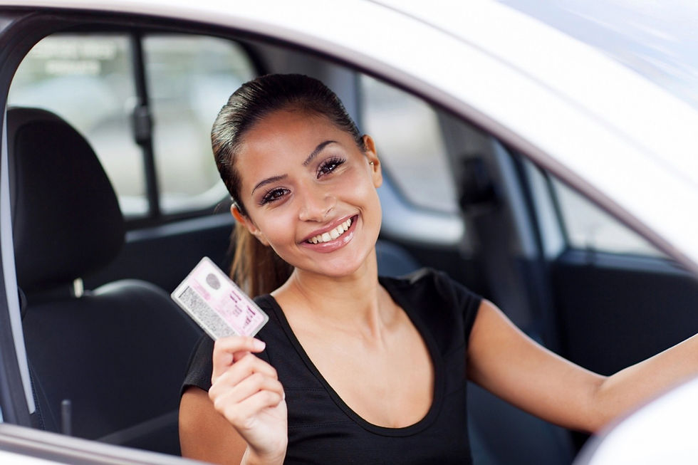 Young woman inside a car holding her new driver’s licence