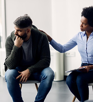 black-female-therapist-supporting-man-who-is-talking-abut-his-issues-during-group-meeting.