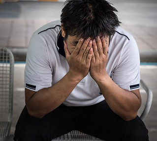 man-fired-from-job-sitting-sad-outside-office.jpg