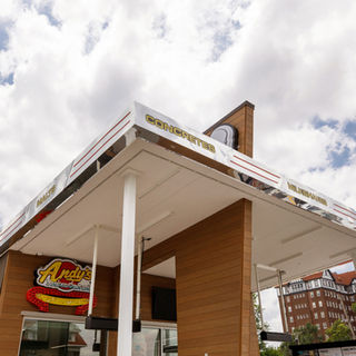Low-angle view of the Andy's Frozen Custard canopy, signage, and wood-look exterior cladding.