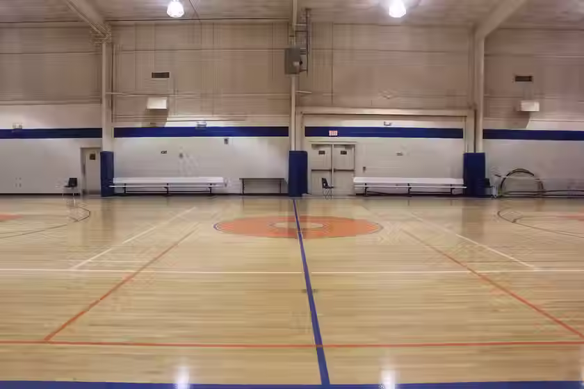 Indoor basketball court with hoops and benches
