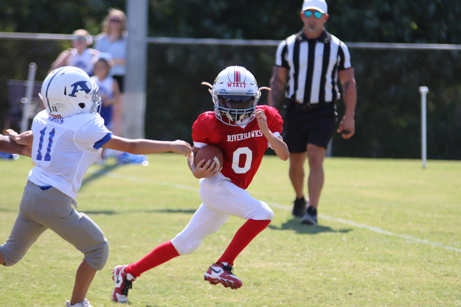 Youth football player running with ball