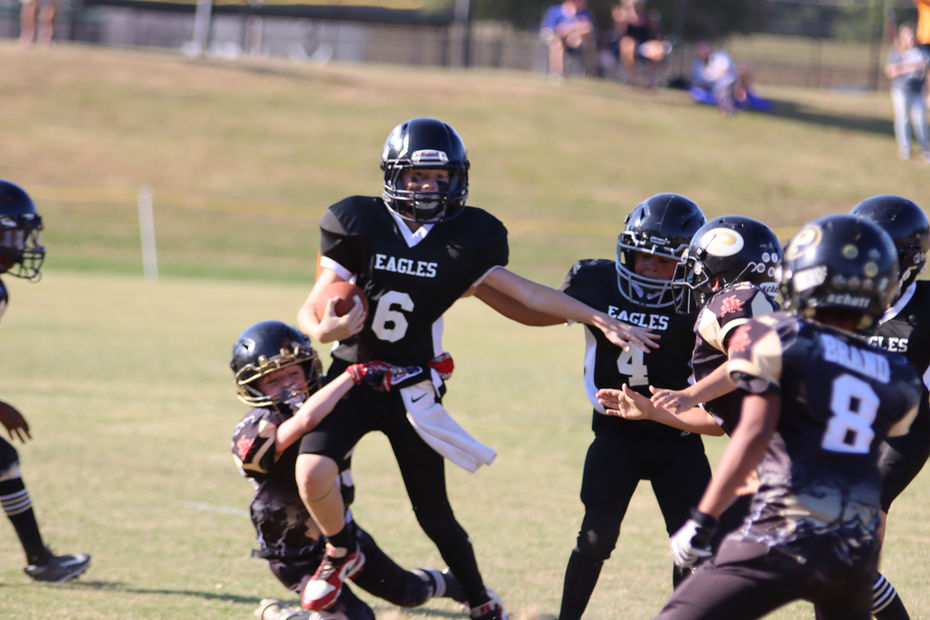 Youth football game: player #6 advances the ball