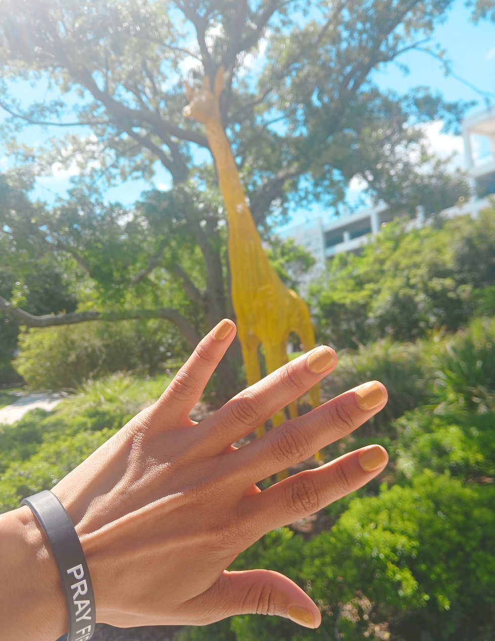 Sculpture Garden Yellow giraffe sculpture and yellow nail polish Journey Orlando pray first black wristband