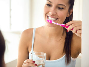 een jonge vrouw poets haar tanden