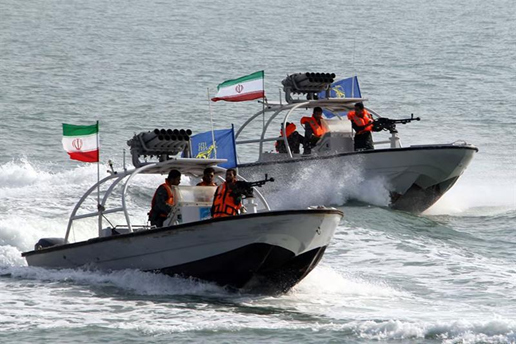 Barcos militares iranianos em ação, com soldados de coletes laranja. Bandeiras do Irã ao vento, em um mar agitado. Emoção de vigilância.