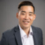 Lane Kawaoka, former engineer turned real estate investor and host of The Wealth Elevator podcast, smiling in a professional headshot during an interview on passive investing strategies.
