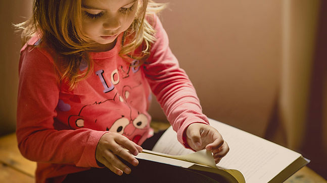 Child turning the pages of a book.