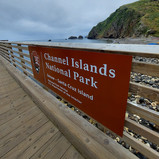 The park sign on the wooden dock that reads “Channel Islands National Park” and “limuw - Santa Cruz Island”