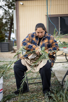 A person sits holding plants