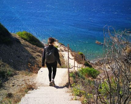 Femme qui marche le long d'un chemin vers la mer, elle est heureuse d'avoir trouvé sa voie