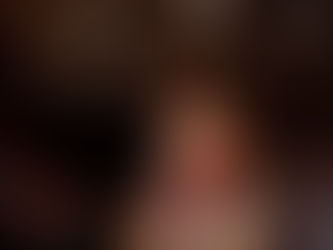 Boxer in a pink outfit with red gloves celebrates in a boxing ring, lights overhead. Trainer in the corner, action-packed and intense.