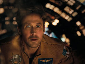 Astronaut in a brown suit looks focused inside a dimly lit spacecraft, surrounded by illuminated panels. Patch reads "GRACE."
