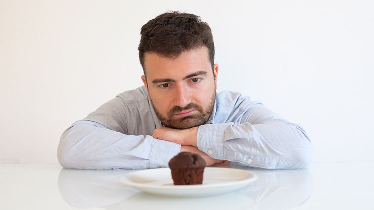 A man staring longingly at a muffin
