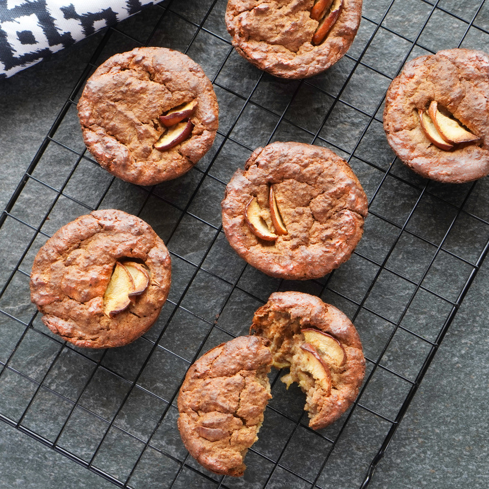 Warm apple and oat muffins cooling on a wire tray