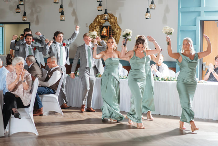 Bridesmaids and groomsmen dancing at a wedding reception.