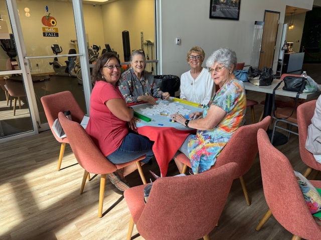 Four seniors playing a board game together.
