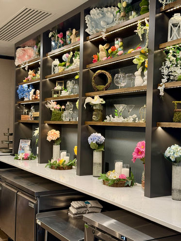 Shelves at the bar with floral arrangements and glassware.