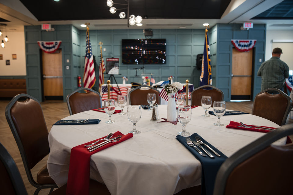 Hightower Room set with round tables with white tablecloths and chairs.
