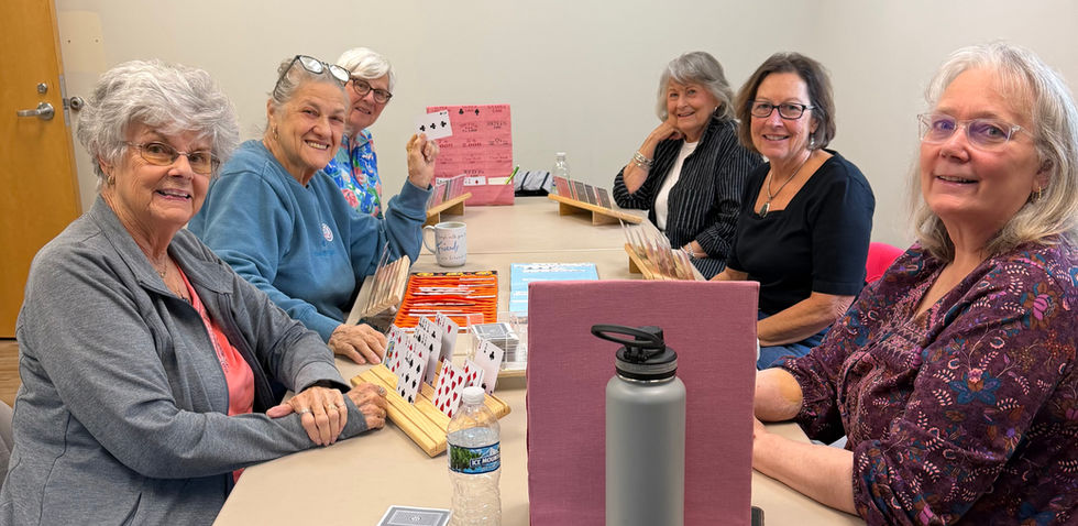 Seniors playing a card game at a table.