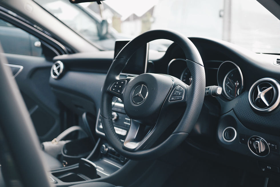 Car dashboard with steering with a Mercedes logo on it