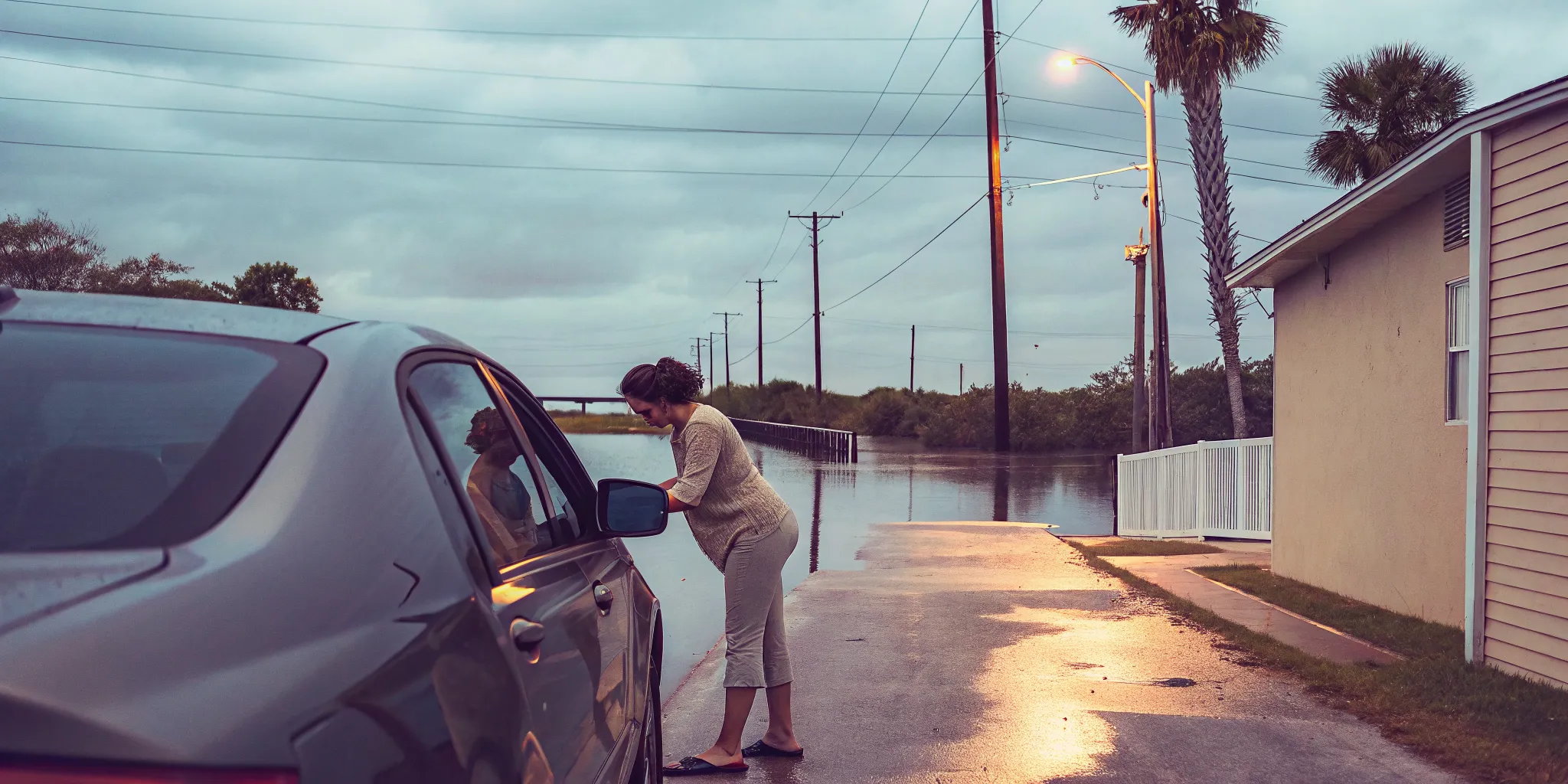 Driver performing a hurricane car protection inspection after a Gulf Coast storm
