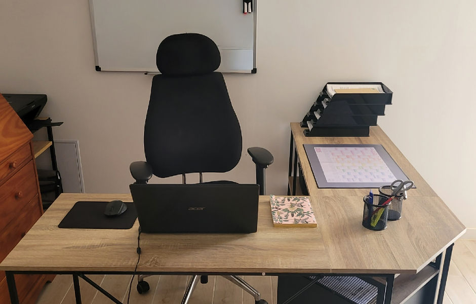 Un bureau de secrétaire indépendante avec ordinateur, cahier, rangements