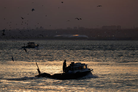 a boat in the water with a man on it that says yavuz on the side