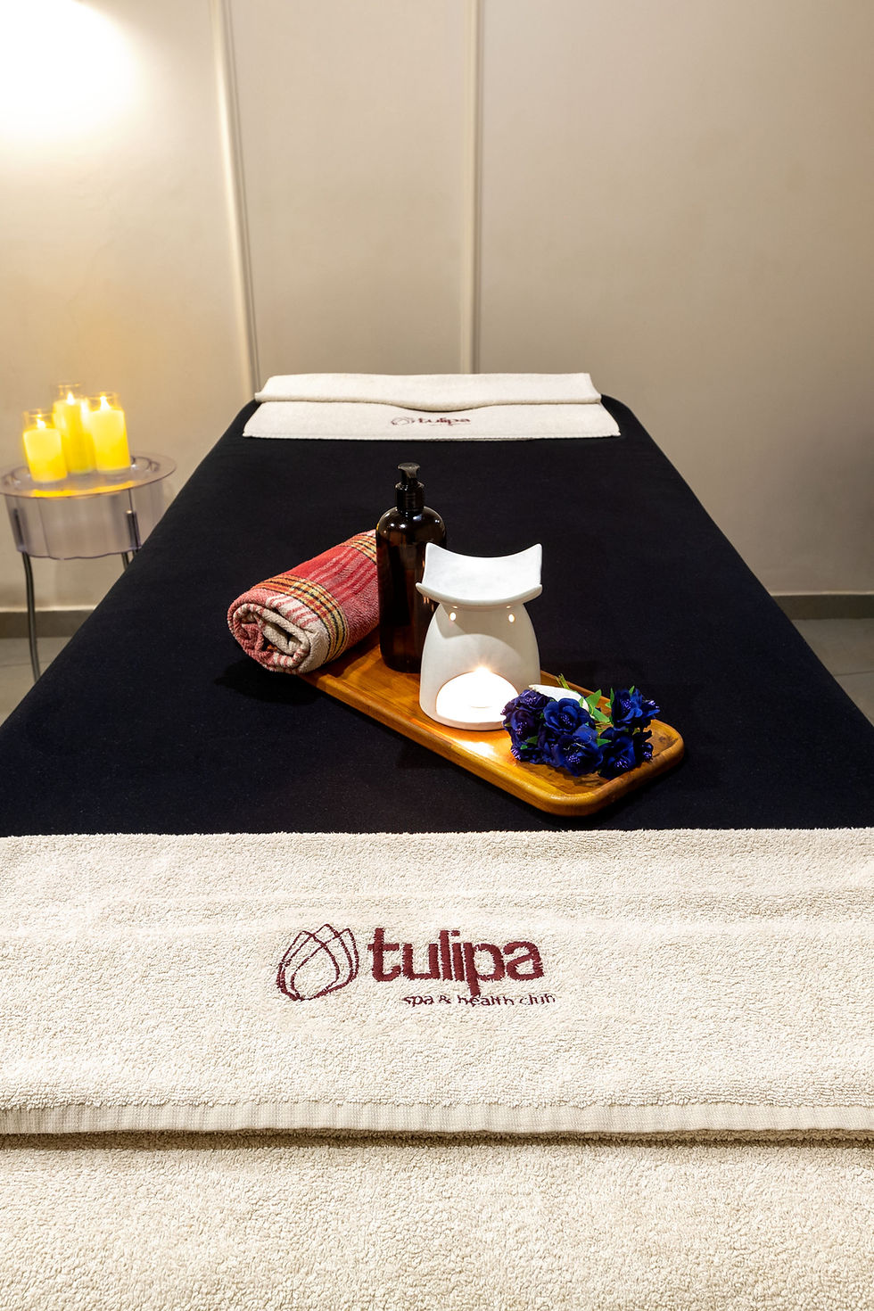 Spa bed with towels, a tray, and 'tulipa' logo, for relaxation and wellness