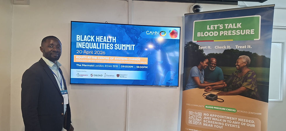 Man in a suit stands next to screens showing "Black Health Inequalities Summit" and a "Let's Talk Blood Pressure" banner. Bright, professional setting.
