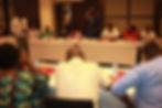Man speaking at an NGO meeting in Kenya, attendees listening