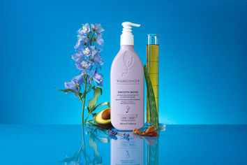 "Smooth Move Bond Reconstruct Conditioner" photographed in Brighton, Sussex by product photographer Stuart Price. The Wild Science Lab product is displayed with blue flowers, avocado, and aloe against a blue background.