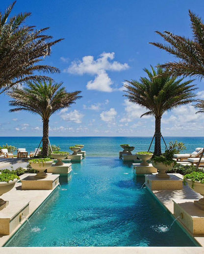 Luxury beachfront resort with an infinity pool, palm trees, and ocean views