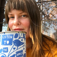 a picture of alice broadway, a white woman with brown hair. The image shows alice's face slightly hidden by a blue and white mug