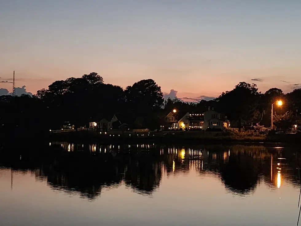 Eye-level view of a dock light casting a golden path across rippled water.
