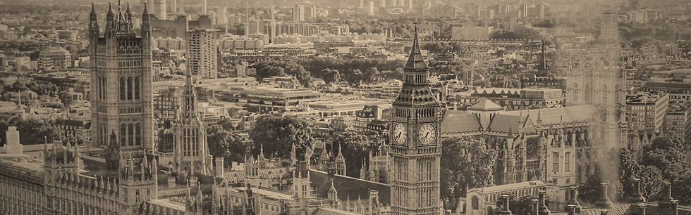 ロンドン市街を一望したモノクロ写真。中央にはビッグベンと国会議事堂の尖塔がそびえ、背景には近代的な建物や住宅街が広がっている。歴史的建築と都市の広がりが対比的に映し出されている。
