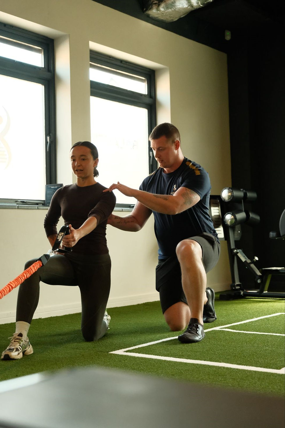 Male personal trainer helping young woman